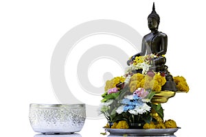 Bronze cast Buddha image decorate with beautiful flowers and garland for pray on Songkarn festival on white background