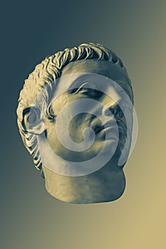 Bronze color gypsum copy of ancient statue of Germanicus Julius Caesar head for artists on brass background. Renaissance