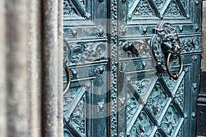 Bronze door with antique brass knocker in the shape of a lion head