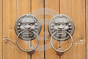 Bronze door handle muzzle Chinese dragon on the background of brown wooden boards.