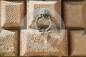 Bronze doorknocker over wall