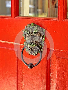 Bronze doorknocker on red wooden door