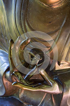 Bronze hands of buddha in meditative pose with fingers.