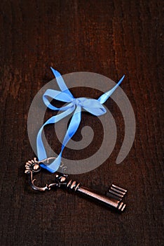 Bronze key with blue ribbon