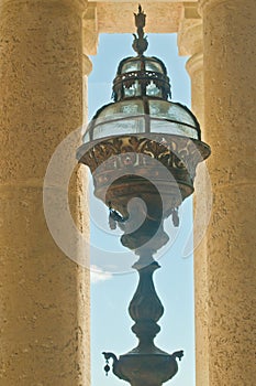 Bronze light fixture hanging in a concrete poetical