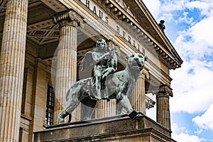 Bronze lion and angel statue in front of the Berlin Concert Hall on Gendarmenmarkt in Berlin