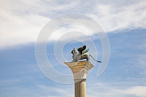 Bronze lion on the Piazza San Marco on blue sky background, Venice, Italy. Winged lion is a symbol of Venice. Ancient statue on a
