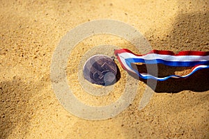 Bronze medal lying on the sand, beach volleyball competitions. Third place