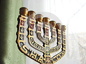 Bronze menorah at window photo