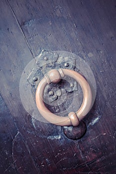 Bronze metal antique vintage door knock or knocker on an old wood door