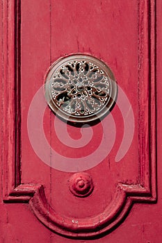 Bronze metal decoration on a red medieval wooden door