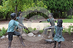 Bronze sculptures of four children playing in a circle at Rotary Botanic Gardens in Janesville, Wisconsin