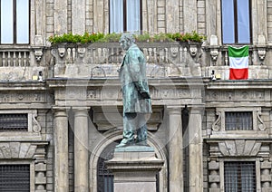 Bronze statue of Alessandro Manzoni in Milan, Italy, with Italian flag.
