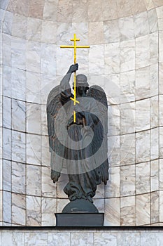 Bronze statue of an angel holding a golden cross