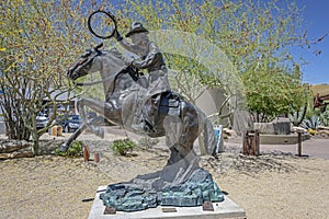 A bronze statue of a cowboy and horse in the Carefree Desert Gardens in Arizona