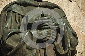 Bronze statue detail of priest hands holding a cross at Caceres photo