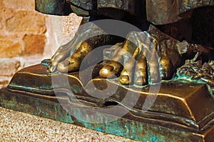 Bronze statue of feet over open book at Caceres