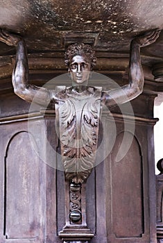 Bronze statue, mythic man supporting a fountain closeup