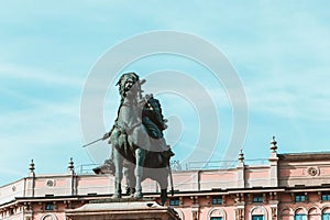 a bronze statue that is next to a building with a clock photo