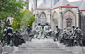 Bronze statue of Van Eyck brothers - Hubert and Jan with St. Bavo`s cathedral on the background