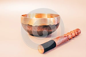 Bronze tibetan singing bowl with wooden stick on the white background