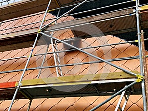 bronze tiles lining the walls of the house, squares similar to fish scales