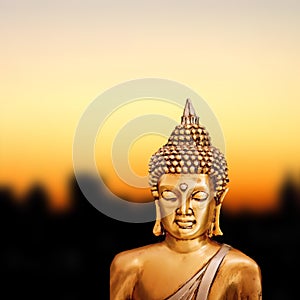 Bronze Zen Buddha Statue on golden sunset background