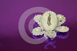 Brooch butterfly handmade from white beads, white artificial pearls and two zircons. The reverse side of the clasp