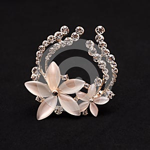 Brooch flower with moonstone and diamonds isolated on black