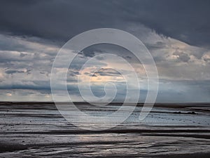 Brooding storm clouds and heavy rain on a beach in northumbria