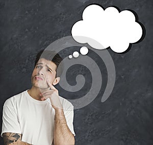 Broody millennial man with blank thought cloud over grey background, mockup for design