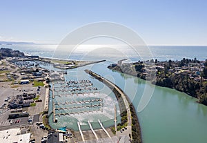 Brookings Oregon marina on sunny day with ocean view, aerial.