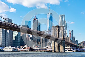 The Brooklyn Bridge with an American Flag over the East River with the Lower Manhattan New York City Skyline