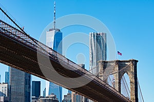 The Brooklyn Bridge with an American Flag over the East River with the Lower Manhattan New York City Skyline