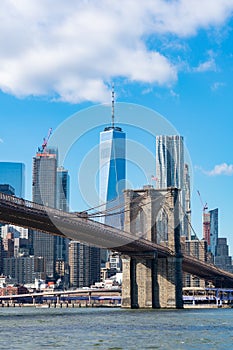 The Brooklyn Bridge with an American Flag over the East River with the Lower Manhattan New York City Skyline