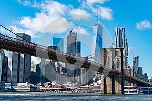 The Brooklyn Bridge with an American Flag over the East River with the Lower Manhattan New York City Skyline