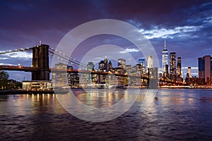 Brooklyn Bridge and Lower Manhattan skyscrapers at dusk with the East River. Manhattan, New York City