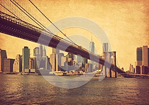 Brooklyn Bridge and Lower Manhattan  in New York City, United States. Photo in retro style. Added paper texture