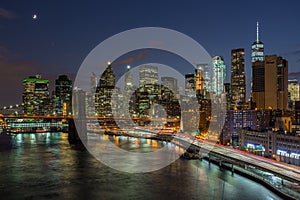 Brooklyn Bridge with lower Manhattan skyline in New York City at night.