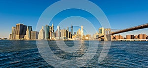 Brooklyn Bridge and the Lower Manhattan skyline panorama from Brooklyn Bridge Park riverbank, New York City, USA