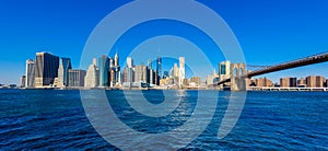 Brooklyn Bridge and the Lower Manhattan skyline panorama from Brooklyn Bridge Park riverbank, New York City, USA