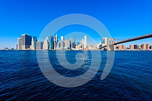 Brooklyn Bridge and the Lower Manhattan skyline panorama from Brooklyn Bridge Park riverbank, New York City, USA