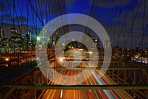 Brooklyn Bridge steel structure with fast moving traffic road at twilight with Manhattan in the background, New York, USA America