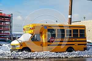 School bus under snow in Brooklyn, New York after massive Winter Storm Gail