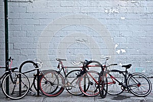 Brooklyn, New York: A group of bicycles chained to sign posts and curbside bike stands on an urban sidewalk