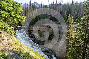 Brooks Falls waterfall in the Shoshone National Forest in Wyoming, Sunbeams lens flare in photo