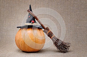 Broom and hat of witch on a pumpkin for Halloween