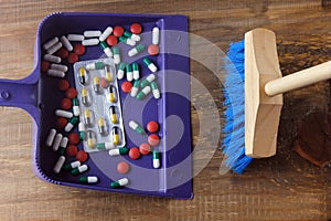 Broom putting medicines in the trash. concept of liberation from dependence on medicines and drugs and detox of the organism