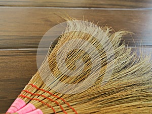 Broom on wooden background