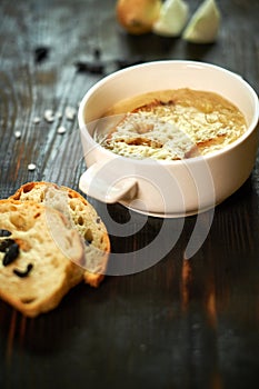 Broth with toasts of bread and black olives